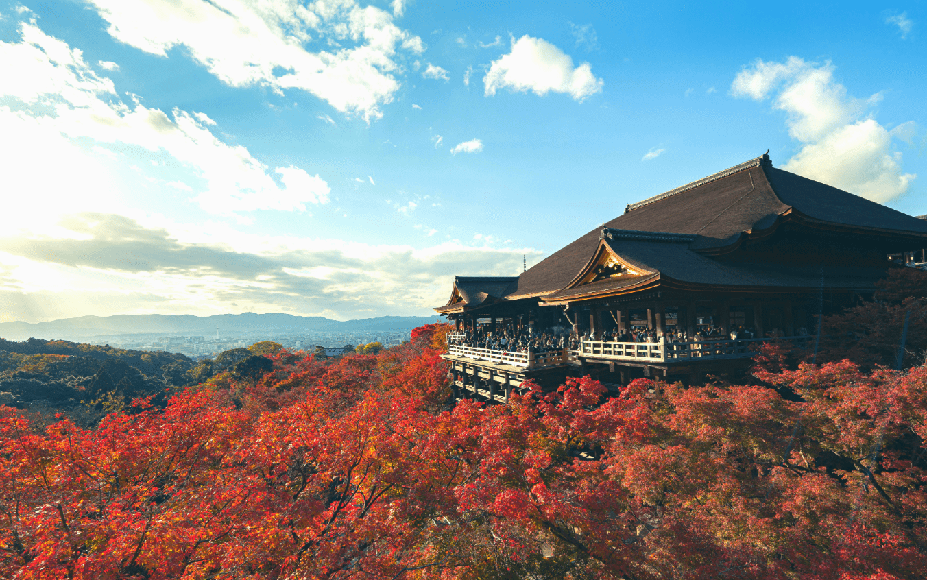 a building with red trees in the background, kyoto kiyomizudera